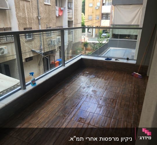 מרפסת עם רצפה רטובה, מטאטא ובקבוק תרסיס ניקוי